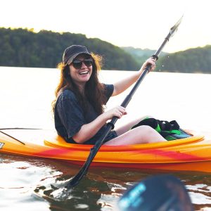 girl smiling in kayak on water